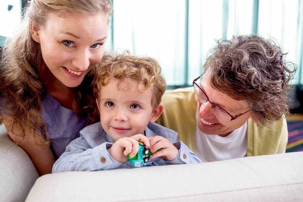 kid smiling with his family by his side