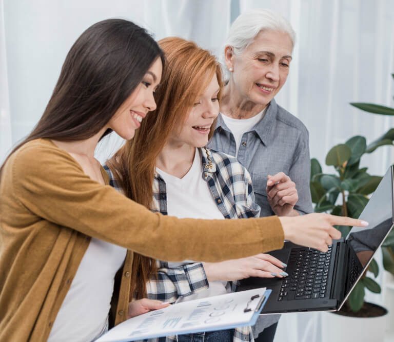 people smiling while looking at the laptop