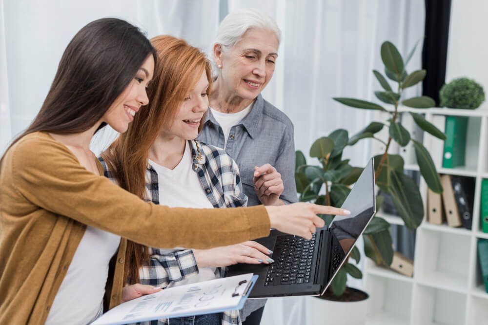 people smiling while looking at the laptop