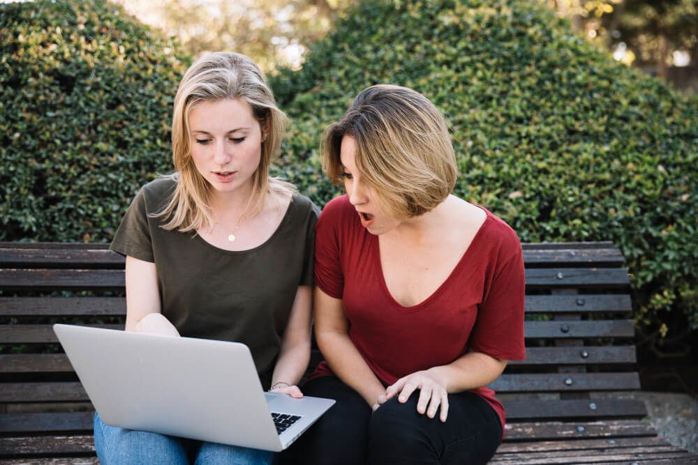 women using laptop having a discussion